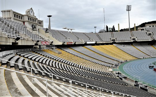 Image of Barcelona Olympic Stadium showing seating area and race track below the famous clock.